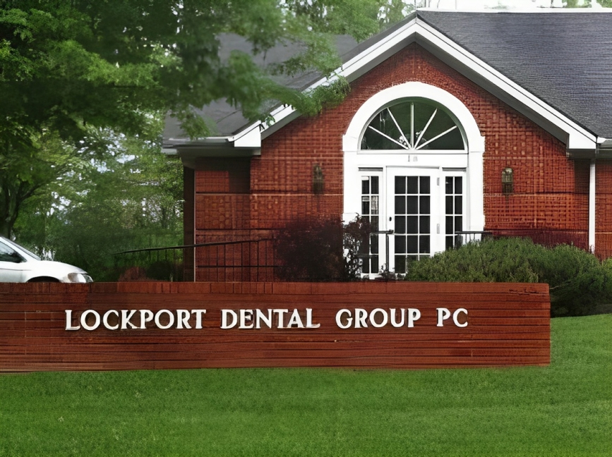 Red brick dental office building with white trim and entrance sign reading "Lockport Dental Group PC"