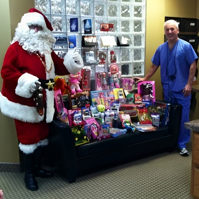 Santa and dentist display toy donations in dental office during holiday charity drive.